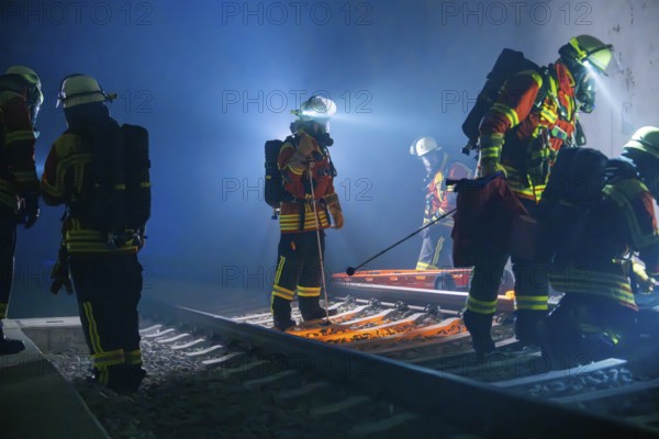 Firefighters working with equipment on tracks in a tunnel, firefighting exercise in the new construction tunnel of the Hermann Hesse railway, Ostelsheim, Calw district, Germany