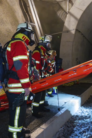 Firefighters in protective clothing stand ready at the tunnel entrance at night, firefighting exercise in the new Hermann Hessebahn railway tunnel, Ostelsheim, Calw district, Germany