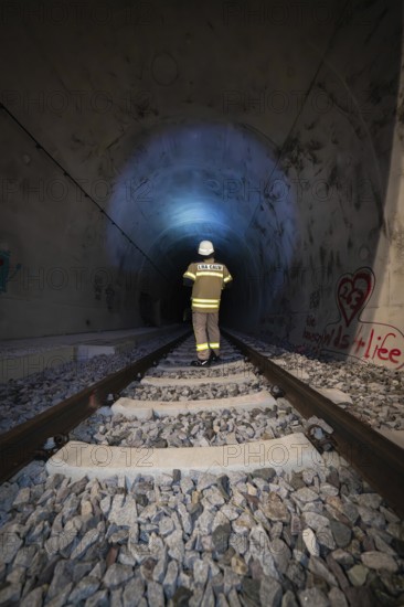 Single firefighter in illuminated tunnel on rails, firefighting exercise in the new tunnel of the Hermann Hesse railway, Ostelsheim, Calw district, Germany