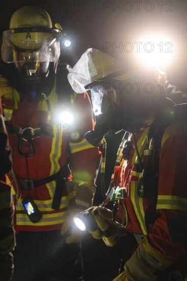 Firefighters in protective suits at night with torches in action, firefighting exercise in the new construction tunnel of the Hermann Hesse railway, Ostelsheim, Calw district, Germany