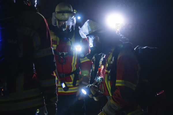 Group of firefighters with breathing masks and lights during a night operation, firefighting exercise in the new construction tunnel of the Hermann Hesse railway, Ostelsheim, district of Calw, Germany