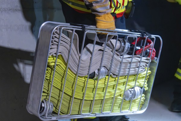 Firefighter carrying hose basket with folded hoses, ready for action, firefighting exercise in the new tunnel of the Hermann Hesse railway, Ostelsheim, district of Calw, Germany