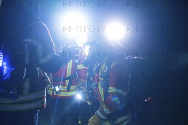 Firefighters illuminated with glare lights, in protective suits, on duty at night, firefighting exercise in the new construction tunnel of the Hermann Hesse railway, Ostelsheim, district of Calw, Germany