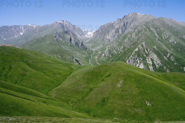 Green hills and majestic mountains under a clear blue sky, at the highest pass in Armenia, Meghri Pass, Tashtun Pass, Syunik Province, Syunik, Armenia