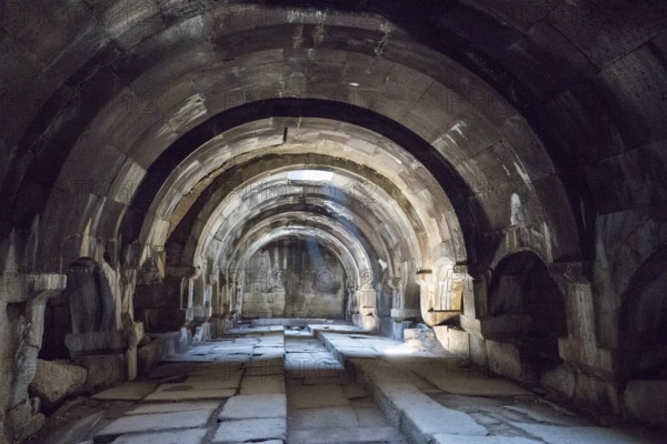 Interior view of an ancient stone vaulted structure with heavy shadow, Orbelian's Caravanserai, Selim Caravanserai, located at the Vardenyats Pass or Selim Pass, Vayots Dzor Province, Armenia