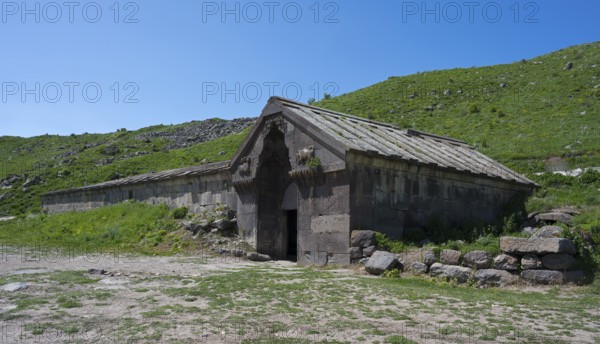 Historic building surrounded by green landscape under a clear sky, Orbelian's Caravanserai, Selim Caravanserai, located at Vardenyats Pass or Selim Pass, Vayots Dzor Province, Armenia