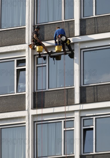 Two male glass cleaners abseiling down the hotel façade to clean windows, aletto Hotel Kudamm, Berlin, Germany