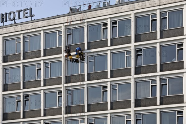 Two male glass cleaners abseiling down the hotel façade to clean windows, aletto Hotel Kudamm, Berlin, Germany