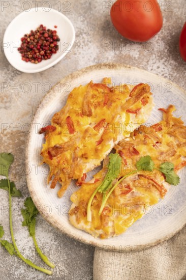 Baked chicken meat with cheese and tomatoes on brown concrete background and linen textile. side view, close up, selective focus