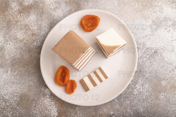 Cocoa and milk jelly with dried apricots on brown concrete background, top view, flat lay, copy space, minimalism