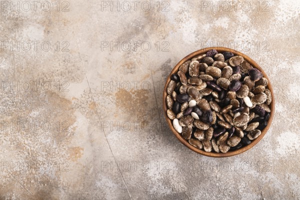 Wooden bowl with Kidney beans on brown concrete background, top view, flat lay, copy space, minimalism