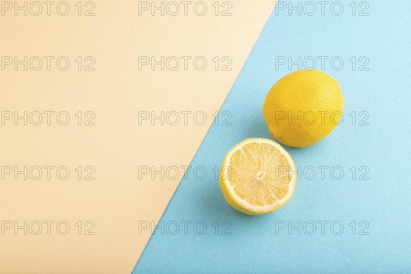 Yellow Lemon Cut in half on orange and blue pastel paper background. Side view, flat lay, copy space. healthy food, vegetable, minimalism