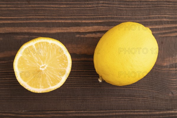 Yellow Lemon Cut in half on brown wooden background. Top view, flat lay, close up. healthy food, vegetable, minimalism. citrus