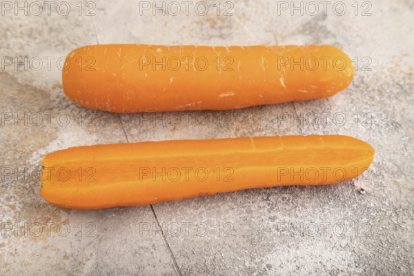 Orange Carrot on brown concrete background. Side view, close up. healthy food, vegetable, minimalism