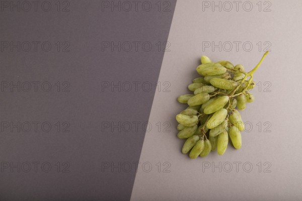 Green grapes on gray and black paper pastel background. Top view, flat lay, copy space. healthy food, minimalism