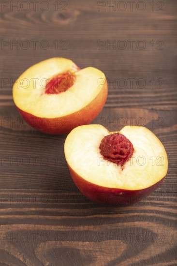 Peach Cut in half on brown wooden background. Side view, flat lay, close up. healthy food, vegetable, minimalism