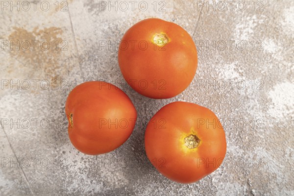 Red tomato on brown concrete background. Top view, flat lay, close up. healthy food, vegetable, minimalism