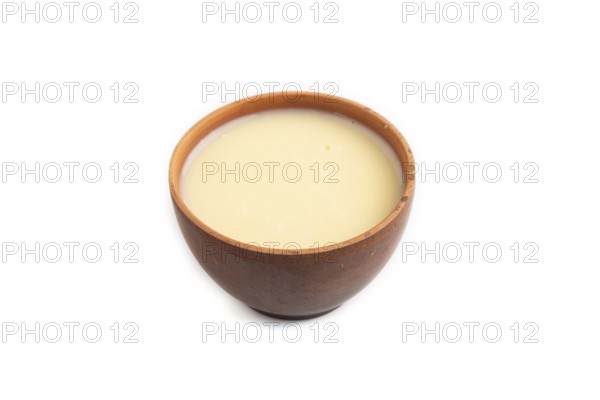 Organic non dairy banana and soy milk in clay cup isolated on white background. Vegan healthy food concept, side view, close up
