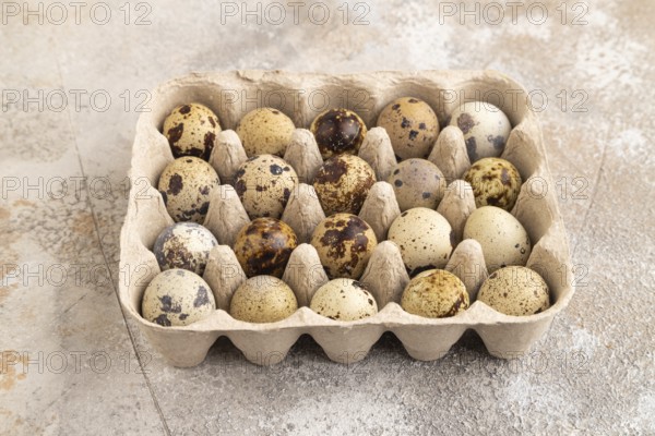 Pile of Raw Quail eggs on a brown concrete background. side view, close up