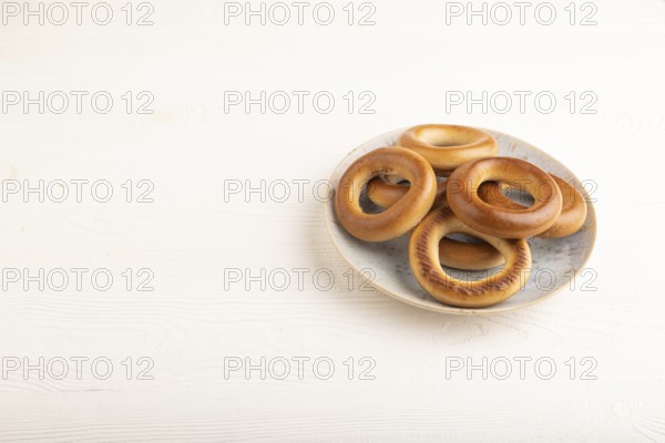 Homemade Ring Bagel on white wooden background. side view, copy space