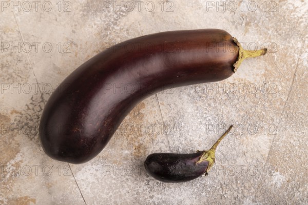 Two Eggplants big and small on brown concrete background, top view, flat lay, close up, minimalism
