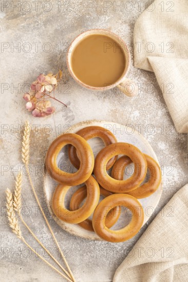 Homemade Ring Bagel with cup of coffee on brown concrete background and linen textile. top view, flat lay, close up
