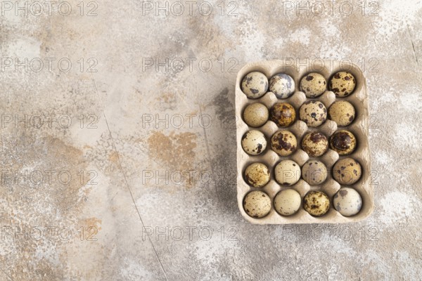 Pile of Raw Quail eggs on a brown concrete background. top view, flat lay, copy space
