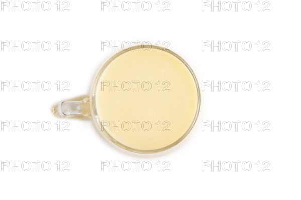 Organic non dairy banana and soy milk in glass isolated on white background. Vegan healthy food concept, flat lay, top view, close up
