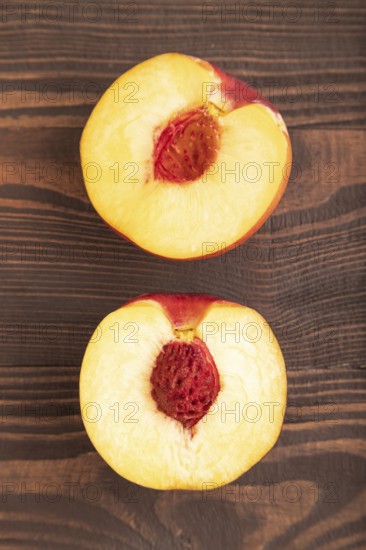 Peach Cut in half on brown wooden background. Top view, flat lay, close up. healthy food, vegetable, minimalism