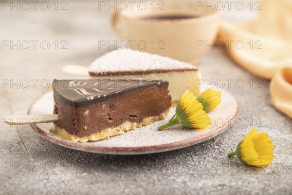 Chocolate and Vanilla Cake pops Marshmallow with cup of coffee on brown concrete background and orange linen textile. side view, close up, selective focus