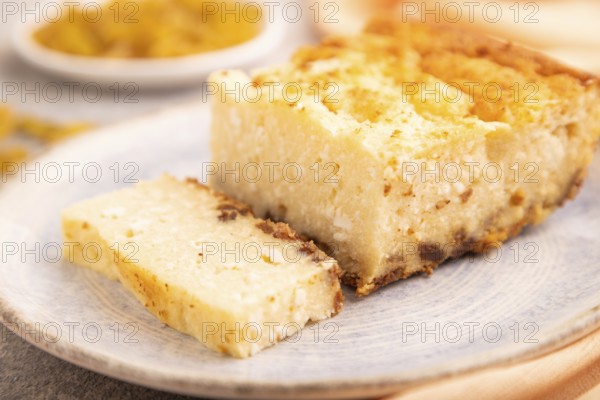 ?ottage cheese ?asserole, Curd cake, with dried apricots and raisins on brown concrete background and orange textile, side view, selective focus, minimalism