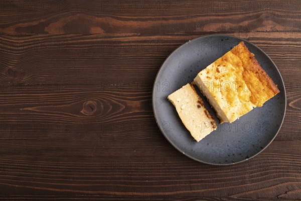 ?ottage cheese ?asserole, Curd cake, with dried apricots and raisins on brown wooden background, top view, flat lay, copy space, minimalism