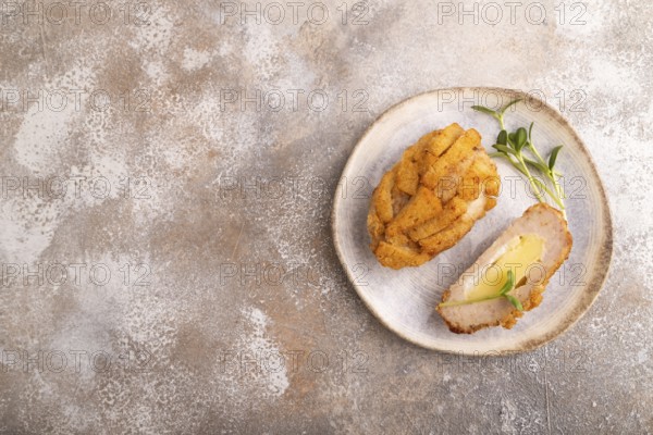 Chicken schnitzel on blue plate with microgreen on brown concrete. Diet, healthy eating. top view, copy space
