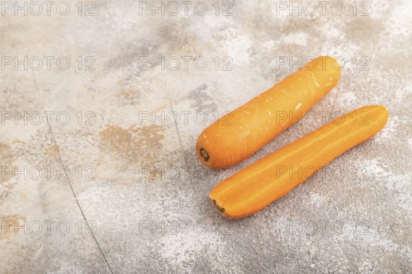 Orange Carrot on brown concrete background. Side view, copy space. healthy food, vegetable, minimalism