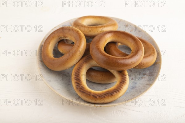 Homemade Ring Bagel on white wooden background. side view, close up