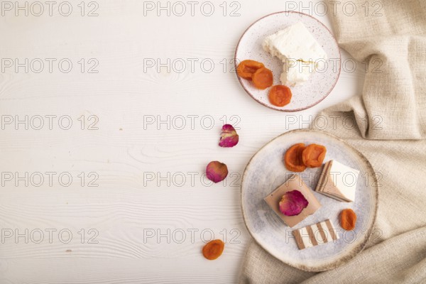 Cocoa and milk jelly with dried apricots on white wooden background and linen textile, top view, flat lay, copy space, minimalism