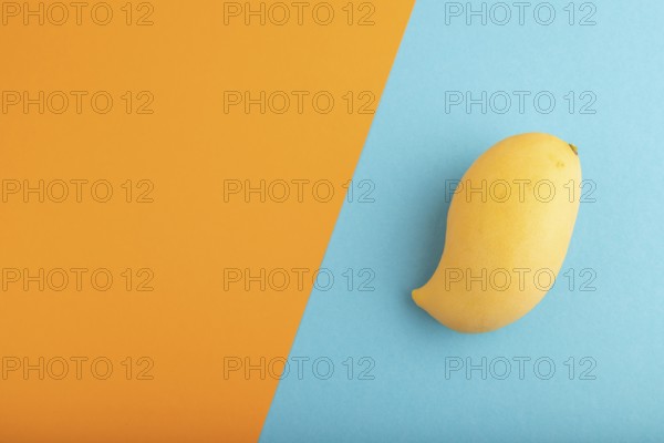 Orange mango on orange and blue paper pastel background. Top view, flat lay, copy space. healthy food, minimalism