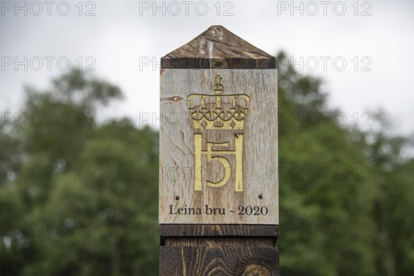 Wooden pillar with golden crown and inscription, Leina Bru wooden bridge, Kongevegen or King's Path over Dovrefjell, Olavsweg or Olavsleden pilgrimage route, Gudbrandsdalen or Gudbrandsdalen valley, Norway