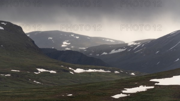 Lonely plateau with snowfields, low clouds, Kongevegen or King's Road, Olavsleden pilgrimage route, Dovrefjell, Oppdal municipality, Trøndelag county, Norway