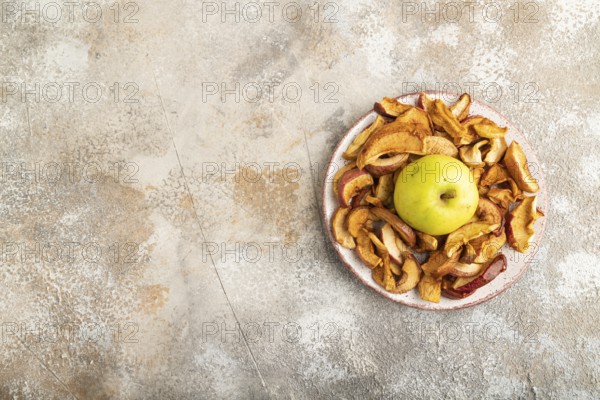 Dried Apples in ceramic bowl on brown concrete background. Top view, copy space, flat lay. healthy food, minimalism. sweet