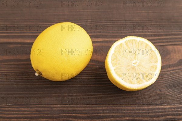 Yellow Lemon Cut in half on brown wooden background. Side view, close up. healthy food, vegetable, minimalism. citrus