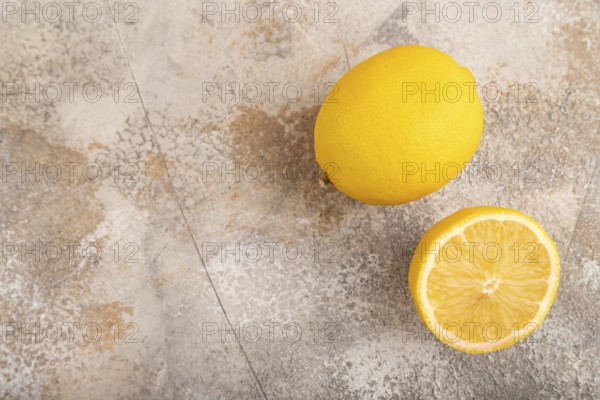 Yellow Lemon Cut in half on brown concrete background. Top view, flat lay, copy space. healthy food, vegetable, minimalism. citrus