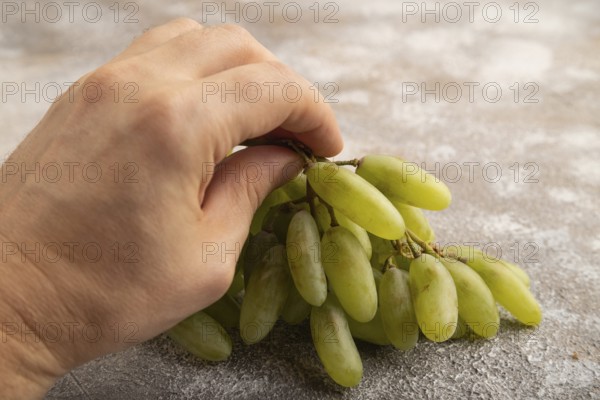 Green grapes on gray concrete background. Side view, close up. healthy food, minimalism
