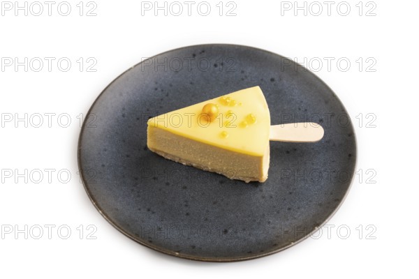 Yellow Cake pop with sprinkles on blue ceramic plate isolated on white background, side view, close up, minimalism