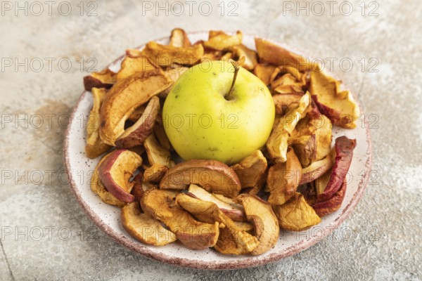 Dried Apples in ceramic bowl on brown concrete background. Side view, copy space, flat lay. healthy food, minimalism. sweet