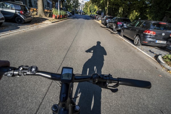 Cycling in the city, city centre street, shadow of the biker, cyclist perspective, Essen, North Rhine-Westphalia, Germany