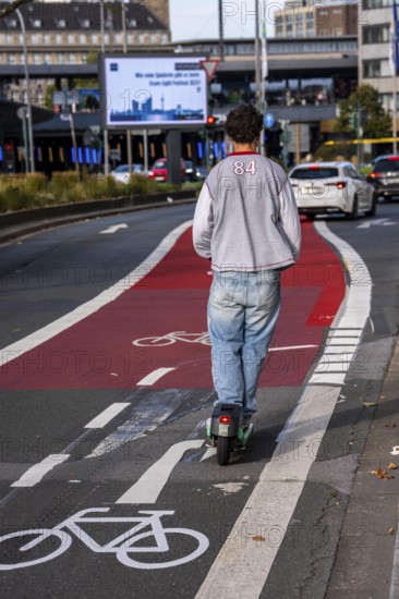 E-scooter on cycle path, cycle lane, marked in red to draw the attention of motorists to the cycle path, between 2 lanes, Huyssenallee, in front of Europaplatz, in the city centre of Essen, North Rhine-Westphalia, Germany