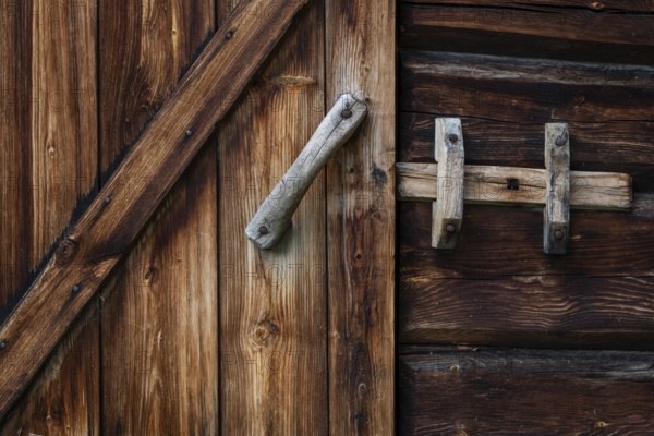 Nahaufnahme eines rustikalen Holztürbeschlags mit einem einfachen Riegel, historischer Bauernhof und Pilgerunterkunft Budsjord, Dovre, Pilgerweg Olavsweg oder Olavsleden, Gudbrandsdalen oder Gudbrandstal, Norwegen