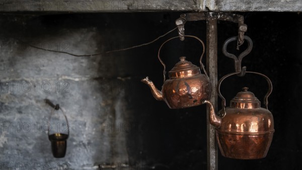 Alte Kupferkessel, die an Haken in einer rustikalen Küche hängen, historischer Bauernhof und Pilgerunterkunft Budsjord, Dovre, Pilgerweg Olavsweg oder Olavsleden, Gudbrandsdalen oder Gudbrandstal, Norwegen