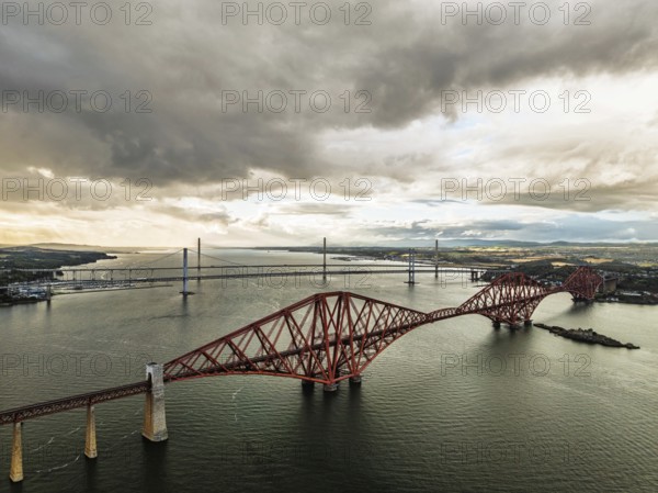Rain clouds over Forth Bridge from a drone, Queensferry Crossing, Forth Estuary, Scotland, United Kingdom